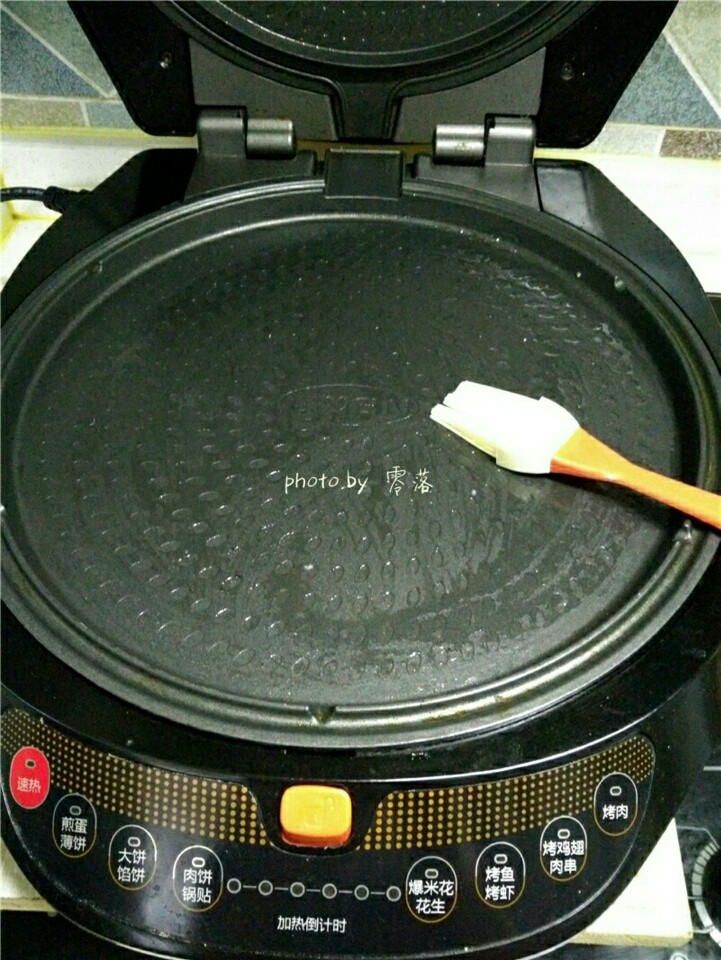香煎腊肉,电饼铛刷油,启动“预热”程序;