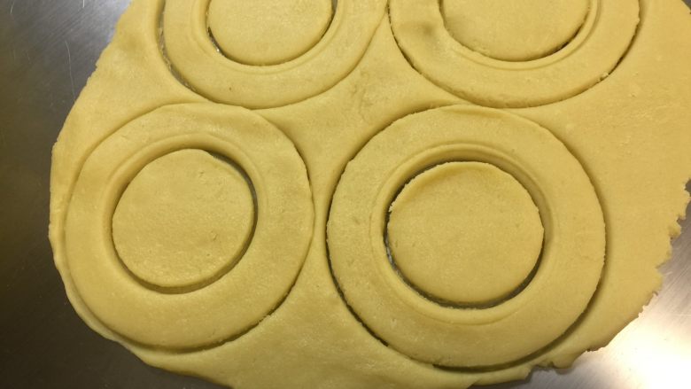 甜甜圈饼干,用甜甜圈模具压出甜甜圈形状,没有模具的可以用瓶子或其他圆形的东西压出甜甜圈形状。