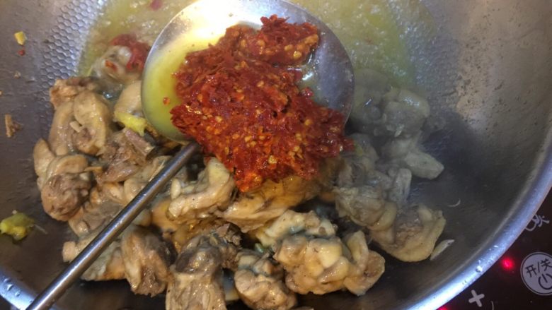 贵州辣子鸡,翻炒几下后,将鸡肉拨到一边,加入粑粑辣椒到滚油中炒散炒香。