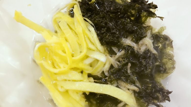 宝宝辅食:虾仁时蔬小馄饨-13M+,将提前准备好的蛋丝(煎蛋切丝),紫菜,和少许盐放在碗中,先盛一点馄饨汤进去化开。
》小芽用的是即食紫菜,如不是即食紫菜,需要提前放入和馄饨一起煮。
