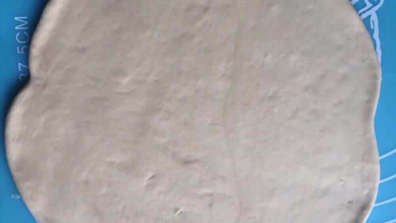 豆沙手撕花样面包,取一个小面团,擀成圆形薄饼。