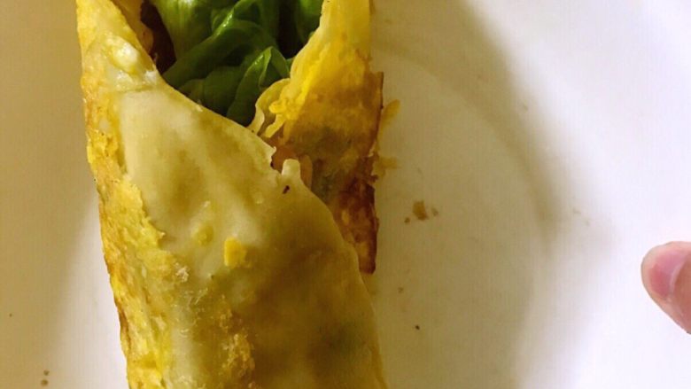 鸡蛋卷饼,酱刷在没有鸡蛋那面,放上生菜,也可以放其他食材,看个人喜好,摆好后卷起来,就可以开吃啦!