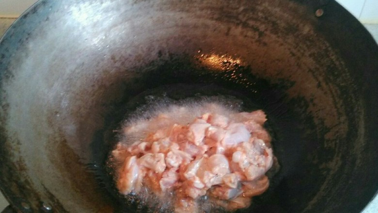 牛蛙香锅,锅里倒入较多的油烧至八成热,倒入牛蛙快速翻炒,炒至断生无血丝,滤油盛出备用