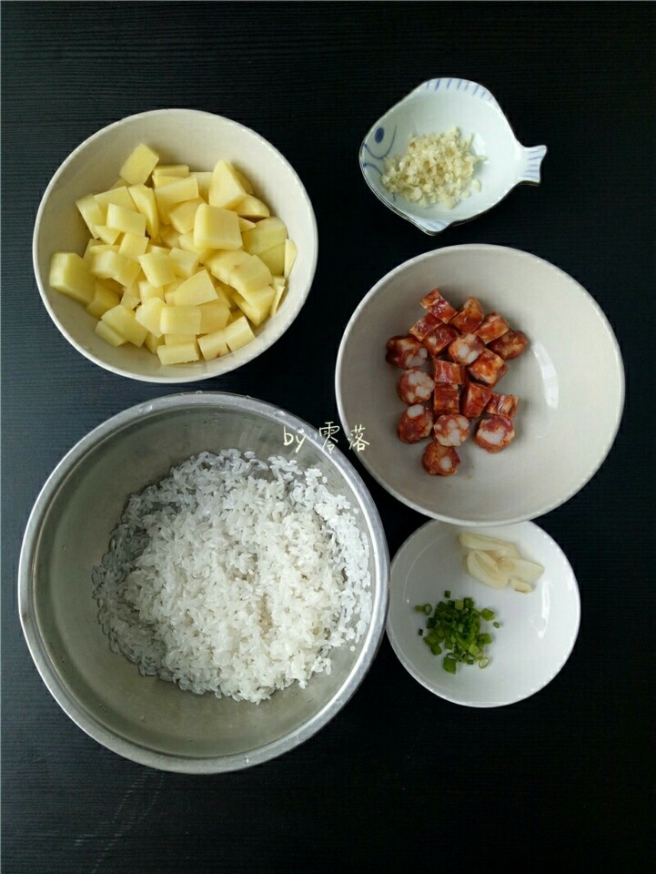 土豆腊肠饭,大米淘洗干净;土豆切丁;腊肠切丁;1瓣大蒜切片;2瓣大蒜切粒;小葱切成葱花;