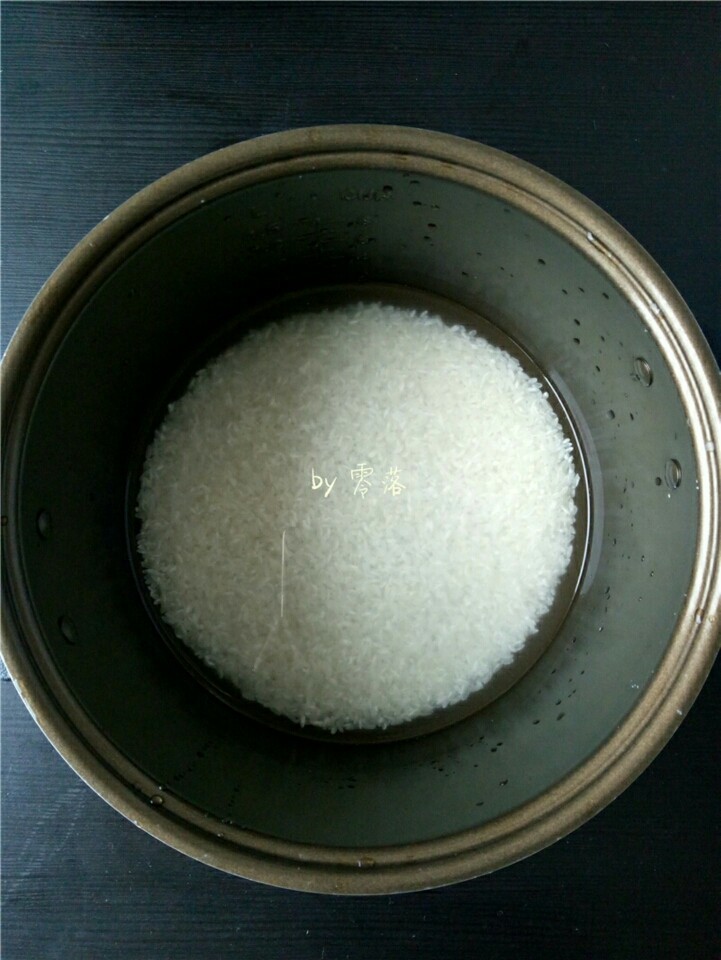 土豆腊肠饭,将大米放入电饭煲内胆,倒入适量清水;具体水量需按平时个人喜好的口感调整;