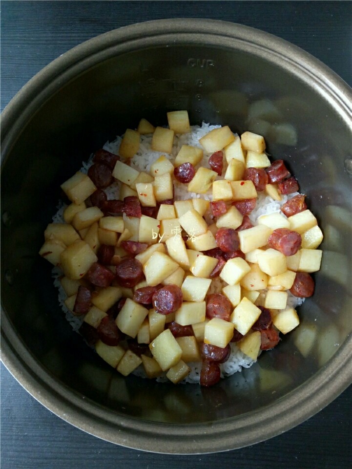 土豆腊肠饭,煮饭程序结束后,将内胆端出(这步可省略);