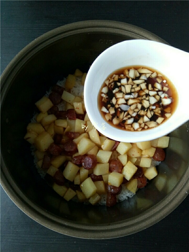 土豆腊肠饭,趁热倒入蒜粒调料;