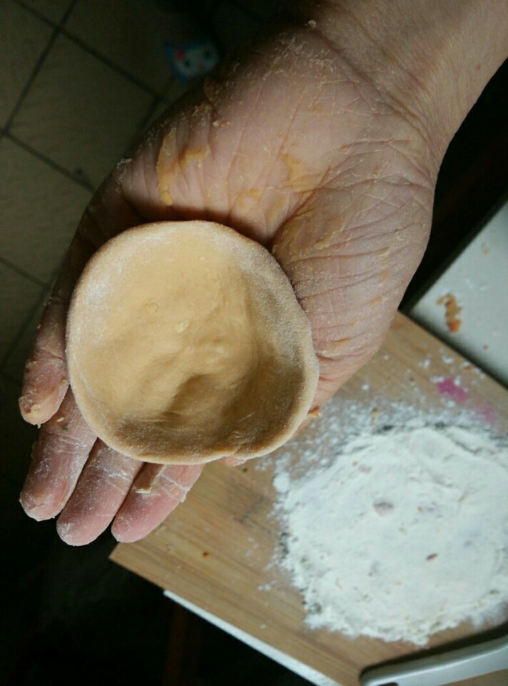 胡萝卜汁皮包子,然后我是用手从边缘慢慢压扁,有点幅度的,有棍子可以用棍子擀称面皮,自己喜欢的厚度!我弄的比较薄,福建做红团的那样薄