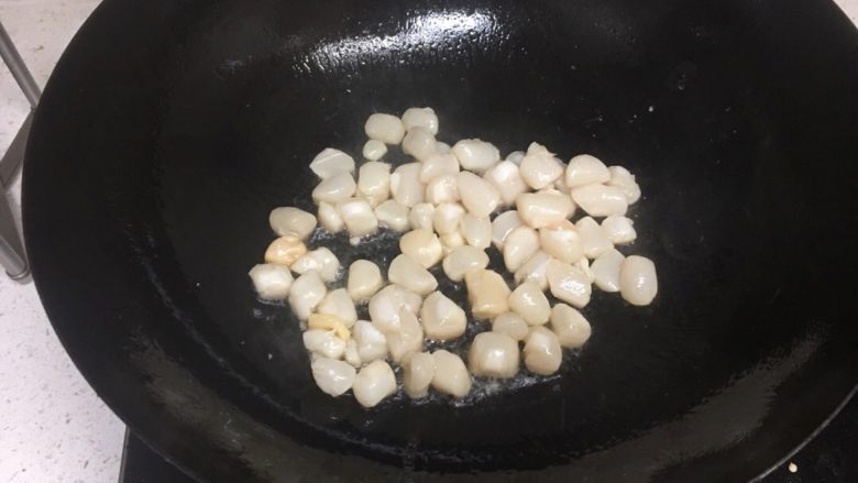 清炒三色扇贝柱,将之前备好的扇贝柱把多余液体倒掉,然后放入油锅,翻炒,一直翻炒,锅铲一直轻轻在锅里晃动着,以防止粘锅,直至锅里水份没了,起盘装待用。