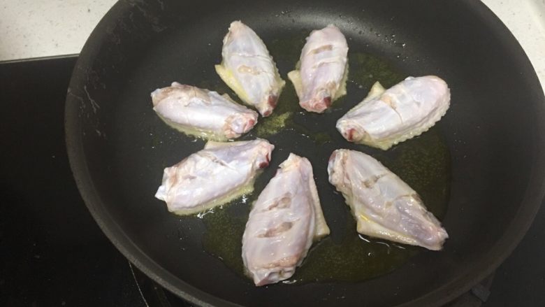 RIo锐澳鸡翅,开小火，这样才不至于手忙脚乱噢，哈哈。油七层热后，用筷子将鸡翅放入锅中。所以当小火，而且油温不会太高时，您用筷子把鸡翅夹着放，是安全的。