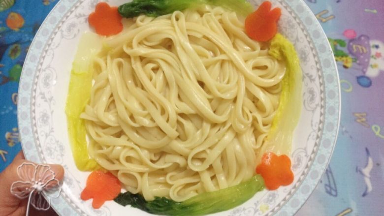 宝宝创意餐--卡通肉酱意面,意面盛入盘中,将蔬菜摆好如图。