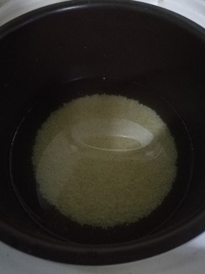 海参小米粥,把小米倒入电饭煲,并放入适量清水。