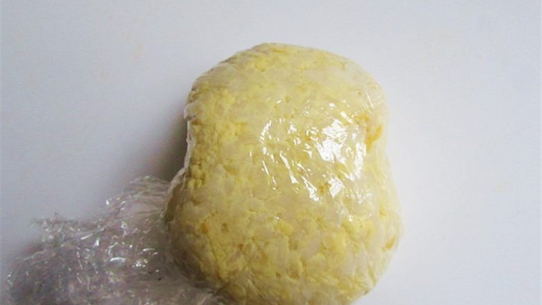 维尼熊便当,用双层保鲜膜把拌好的蛋黄饭包起来团一团再捏整形整出维尼熊的头部大概形状,再去掉保鲜膜即可,并用同样方法捏出两个耳朵