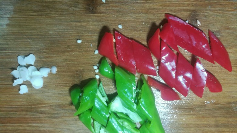 双椒火腿炒鸡蛋,青红椒切菱形块,蒜子切片。