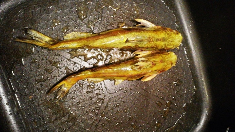 酸雪菜昂刺鱼鹌鹑蛋面,油锅把昂刺鱼的各面煎好装盘备用