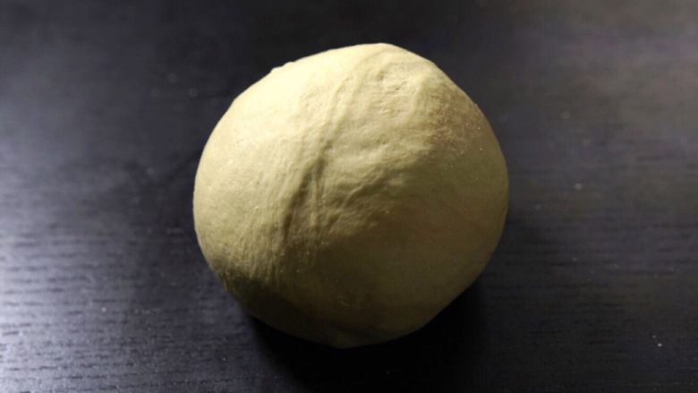 抹茶豆大福软欧,材料搅拌均匀成团后放在桌上揉面
将面揉至出筋,表面光滑的状态,揉面完成