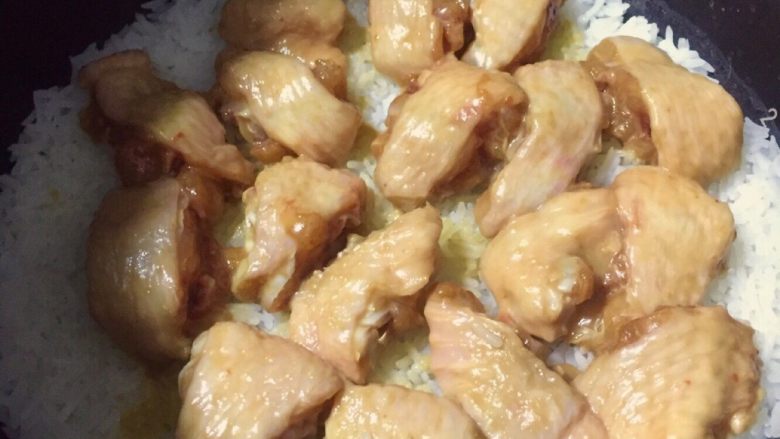 鸡翅鱼蛋香肠电饭煲焗饭,饭开始沸腾便可放入腌制好的鸡翅、均匀铺平就好。如果饭开始干水再放就晚了、很可能会焖不熟。