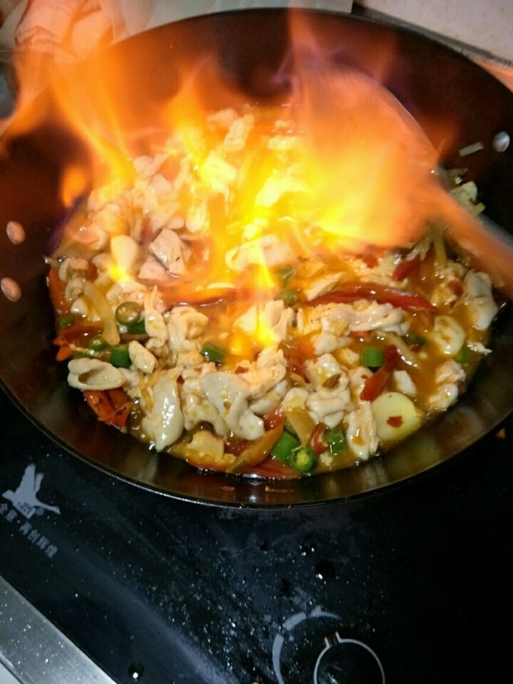 四川麻辣肥肠,倒入生抽炒一会儿,倒入白酒点燃,翻炒。