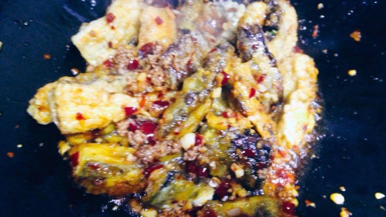 鱼香茄子,将调好的味汁沿锅边滑入一半,快速翻炒均匀。