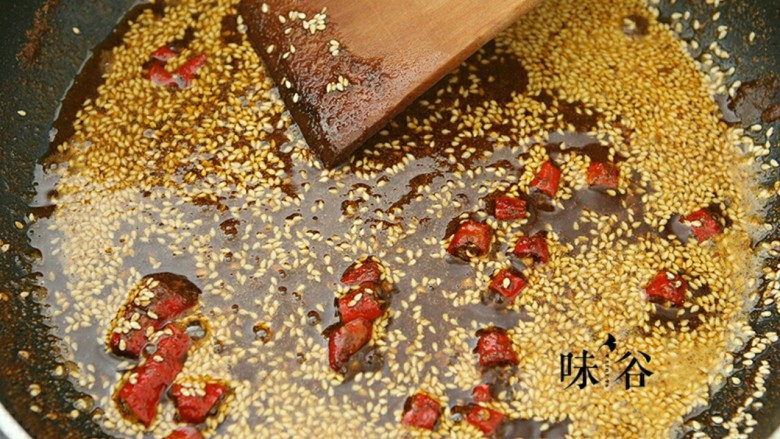 麻辣牛肉条,多余的油倒出,锅内留多点油,油热后倒入芝麻,辣椒粉花椒粉和辣椒进行翻炒,炒到香味溢出。