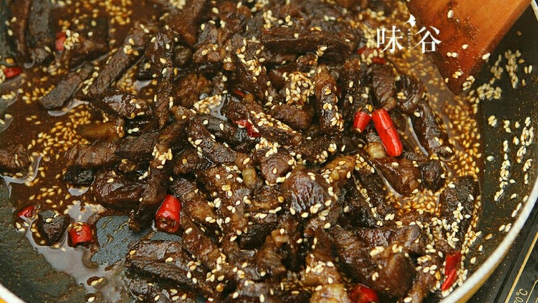 麻辣牛肉条,倒入牛肉翻炒,使牛肉均匀的粘上芝麻和辣椒油,放入适量的糖,盐和酱油,可以试一下味道。