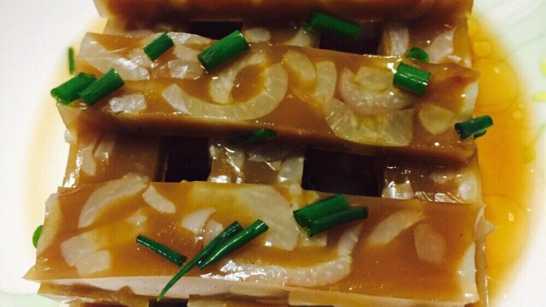 爽口猪皮冻,把猪皮冻里的香料都捞出,放凉后放进饭盒碗等随便的容器内,如果天气热的话要放进冷藏,第二天就做好了,天气冷的话就直接放一夜,我2月份做的,放在外面一夜就自己成型了,想吃的时候拿出来,随便切点造型,放点自己喜欢的调味料,我调的是生抽醋辣油,爽口的皮冻冻,准备开吃吧~