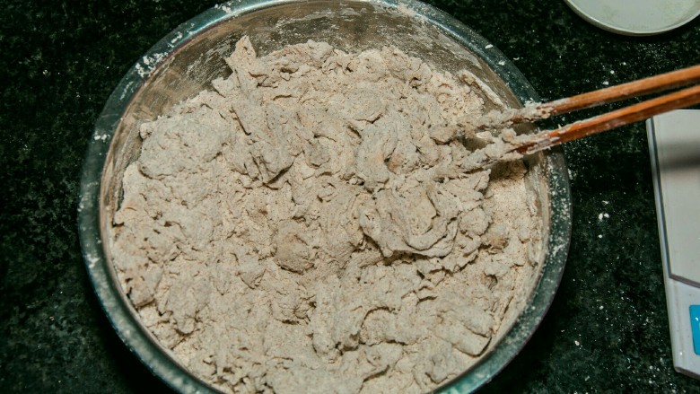 黑麦馒头,再继续缓慢地往面粉里加水,边加边用筷子搅拌。