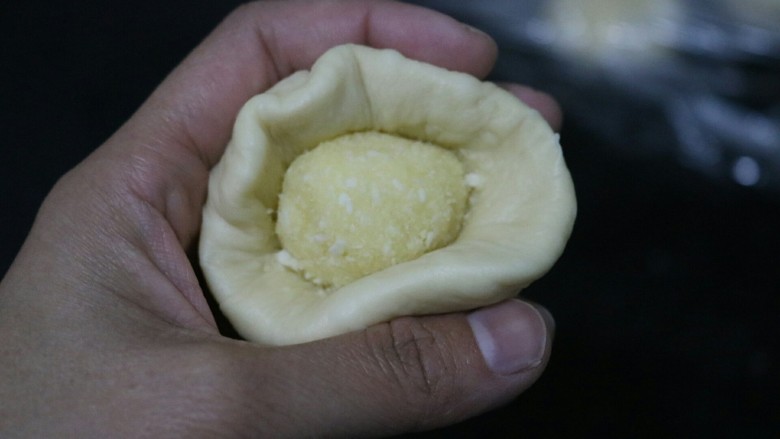 ≈椰蓉面包≈,把面团擀成圆形,包上馅儿,扭紧