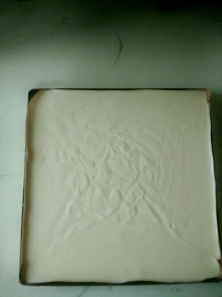 如奶酪芝士般湿润嫩嫩的戚风蛋糕块 肥厚细腻的古早原味,整个蛋糕糊很细腻有光泽,感到空气的轻盈,从8到10厘米的高度倒入烤盘,这样可以防止大的气泡。
因为蛋糕糊比较湿润,所以不用刮刀,直接来回转动烤盘就可以把蛋糕糊铺平。
放入烤箱的最后一个动作就是用手轻烤盘底部,把小气泡振出来