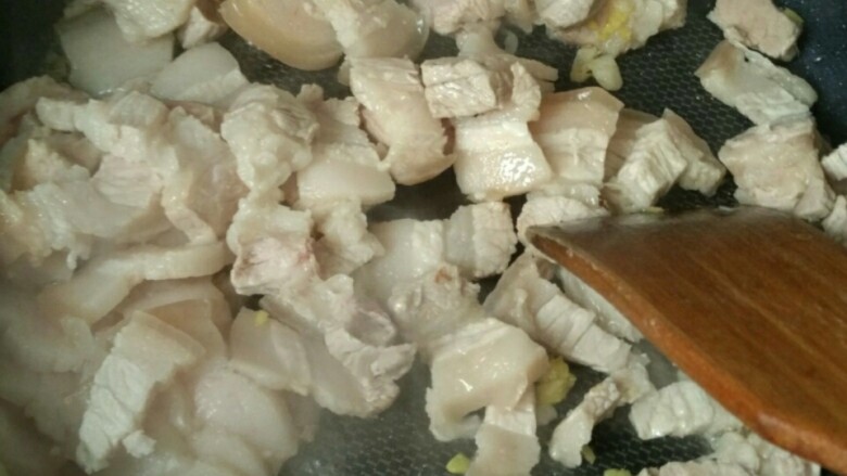 简单易学的家常回锅肉,热锅,下油,放入姜蒜绒,翻炒加入切好的猪肉片,炒两分钟见颜色微黄即可