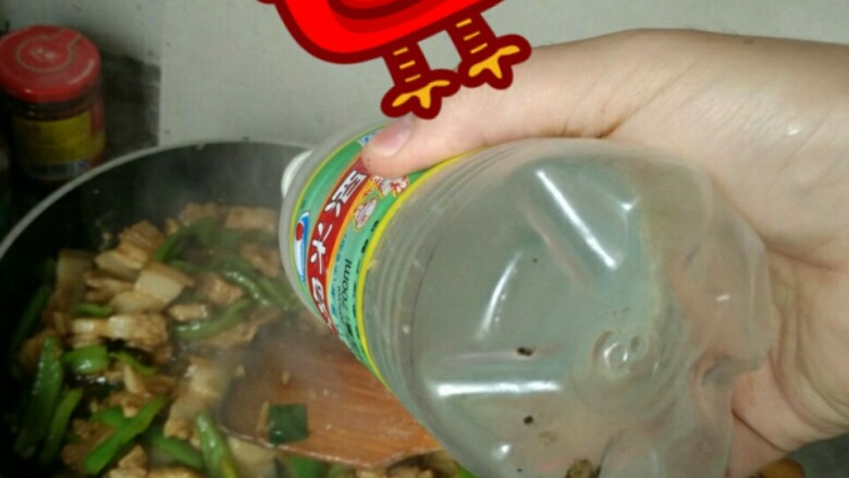 简单易学的家常回锅肉,倒一瓶盖米酒或者料酒,去猪肉的腥味,同时保持青椒的颜色光泽