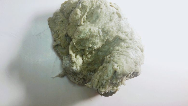 樱花抹茶豆沙面包,材料搅拌均匀成团后放在桌上揉面