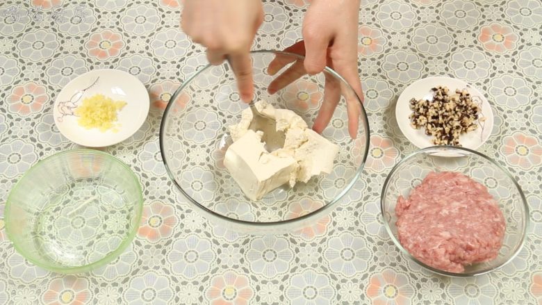 豆腐丸子汤,将豆腐放入一个大碗里,用勺子背面压成豆腐泥,肉末跟豆腐的比例为1:1。