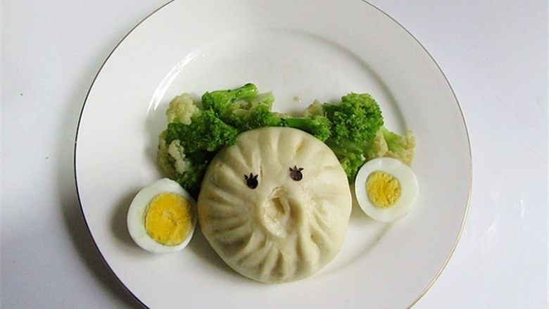 小丑趣味早餐 ,把炒好的西兰花菜、包子和另外备好的<a style='color:red;display:inline-block;' href='/shicai/ 5195'>煮鸡蛋</a>切开两瓣摆成小丑的脸蛋、耳朵、头发,眼睛可以用海苔剪也可以放两个蓝莓果装饰一下即可