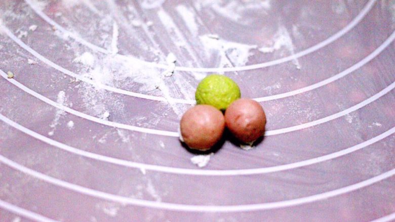 桃花酒酿百合羹(王氏私房菜),取一点你自己喜欢的大小面团、揉成小圆球、其中一个颜色放在中间当花芯、其它的就放在花芯边上、如图、如果不沾、就稍微沾一点清水就可以了……