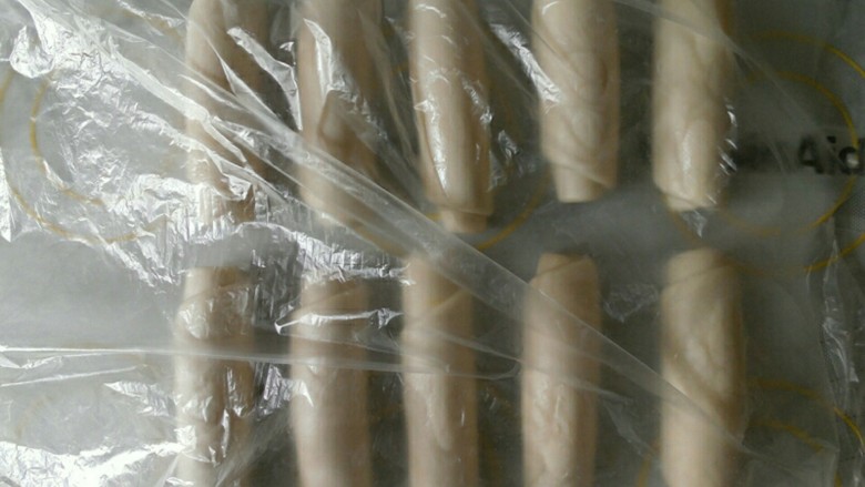 肉松蛋黄酥,所有的都卷好后,盖上保鲜膜 静置五分钟