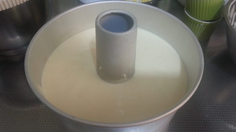 烘焙基础——戚风蛋糕,将面糊倒入模具中,提起模具向下轻摔数下,振出面糊中的气泡。