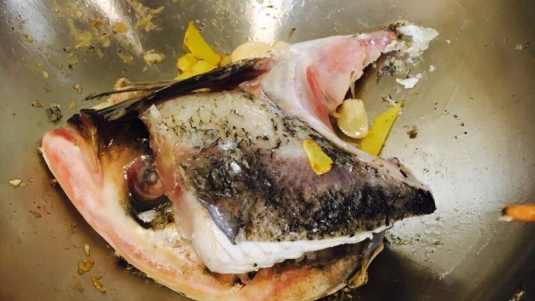 千岛湖鱼头豆腐汤,放入鱼头,煎至金黄