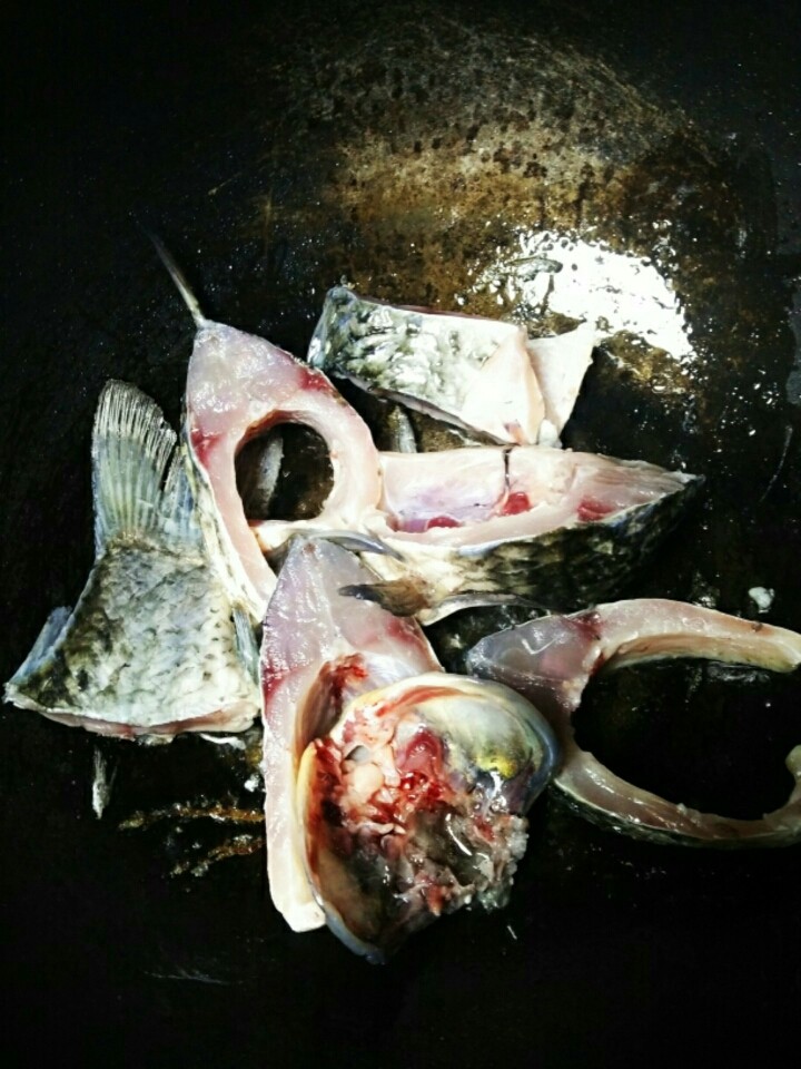鲫鱼豆腐汤,锅加油烧热,加入鱼块,煎至两面金黄。