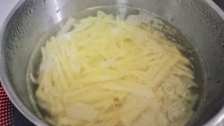素食 | 香菇土豆拌面,将土豆丝放入沸水中,焯3~5分钟,捞起沥干。