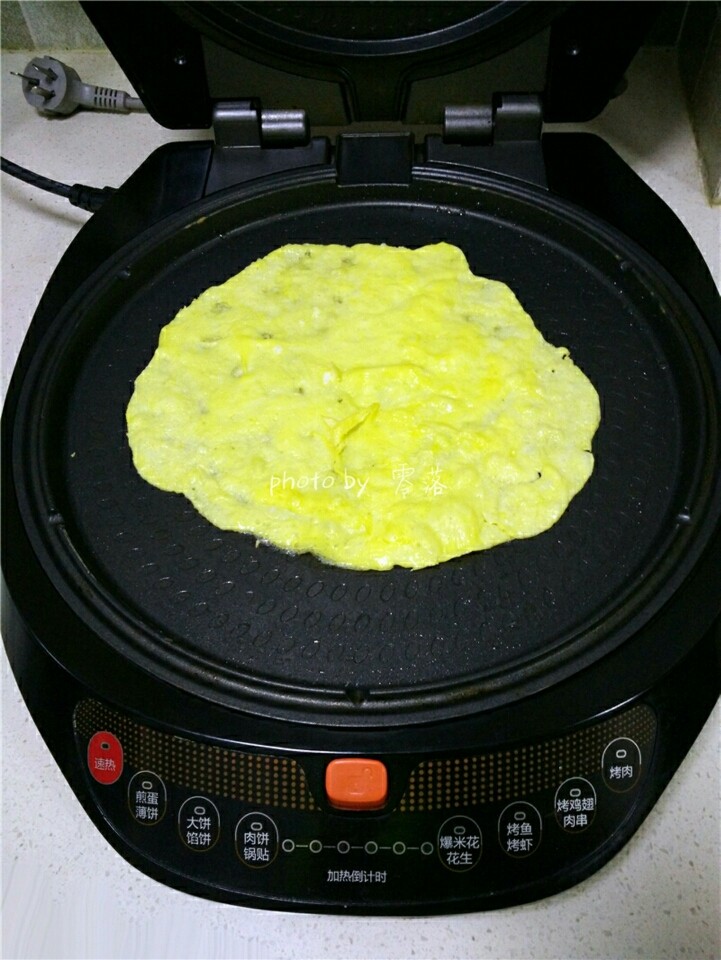 西红柿鸡蛋披萨,电饼铛刷油,倒入蛋液;只打开电饼铛的下开关,启动预热程序;