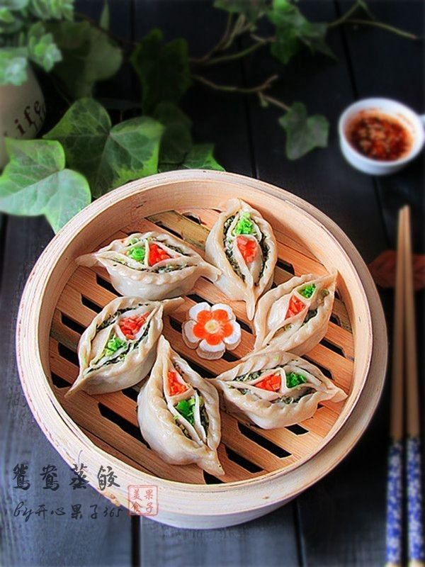 鸳鸯蒸饺 ,蒸好的饺子,蒸熟后要趁热立即把菜叶取下来,接下来为了好看你可以在饺子中心两个坑里分别洒上胡萝卜碎和蒜碎或香菜