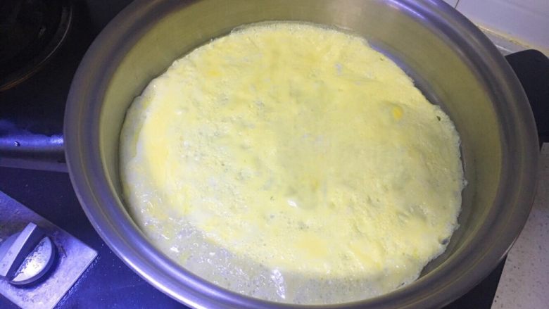 营养蔬菜炒饭,平底锅中加少许油,捣匀,铺满整个锅底,倒入打好的鸡蛋,铺满整个锅底,凝固后,即可取出待用(如果想做蛋包饭的朋友,建议3个鸡蛋,不建议鸡蛋里加牛奶,因为蛋皮太嫩容易破)