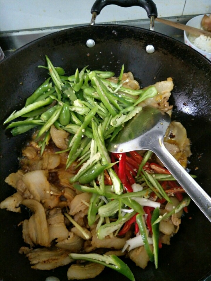 盐煎肉,翻炒上色,加入辣椒生姜蒜翻炒,炒至辣椒断生,,放鸡精孜然粉。