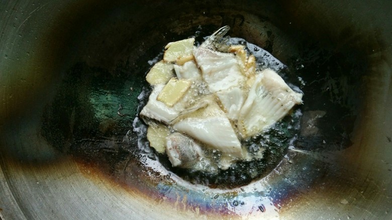 酸菜鱼,热锅上油后,将姜,红辣椒,鱼骨放入锅内煎,