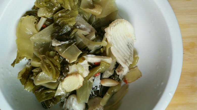 酸菜鱼,将鱼骨酸菜捞起放碗中,将汤继续留在锅内