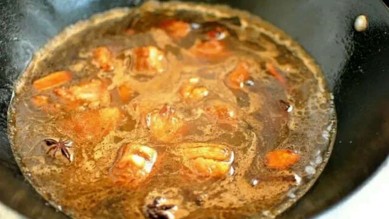 排骨闷饭,加入酱油和老抽继续翻炒让排骨上色,加水没过排骨,再调入料酒和盐调味。