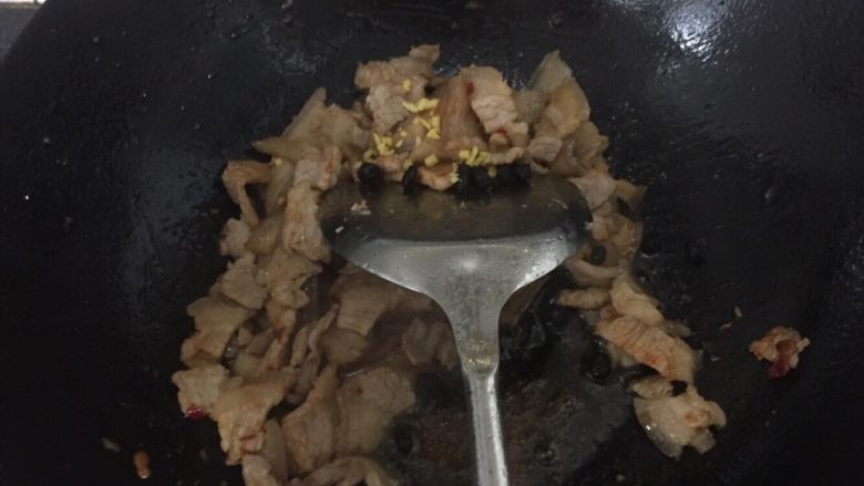 家常回锅肉,加入姜沫和豆豉炒均匀后加入辣椒