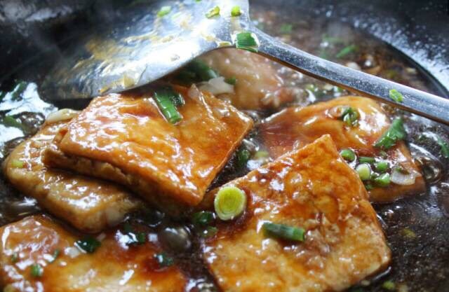 家常豆腐2,加入一大勺生抽,老抽大火烧开。 加入煎好的豆腐。 加入少许芝麻油调味。将浇好的汤汁均匀的浇在豆腐上即可。