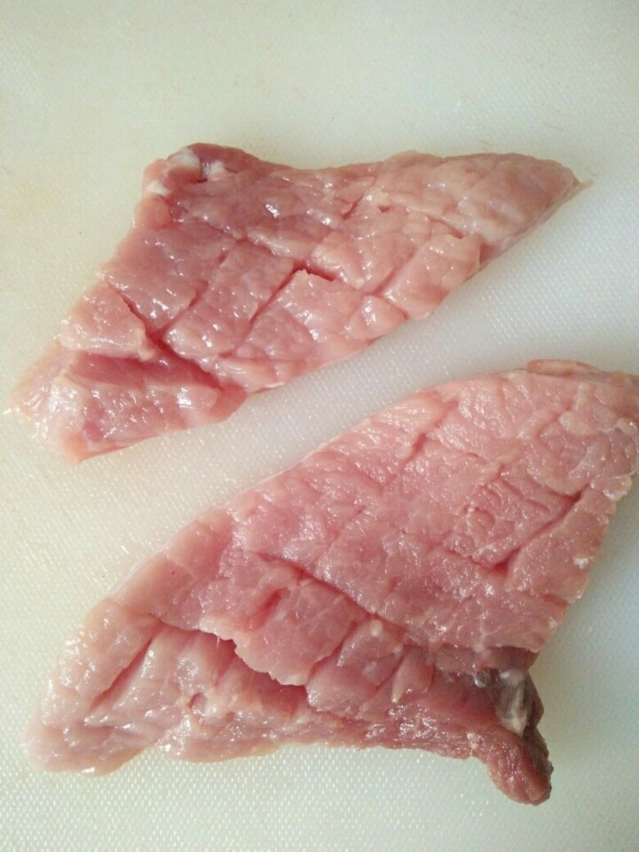家常菠萝咕咾肉,厚肉片轻切花刀（别切断），目的是易炸熟和易入味。